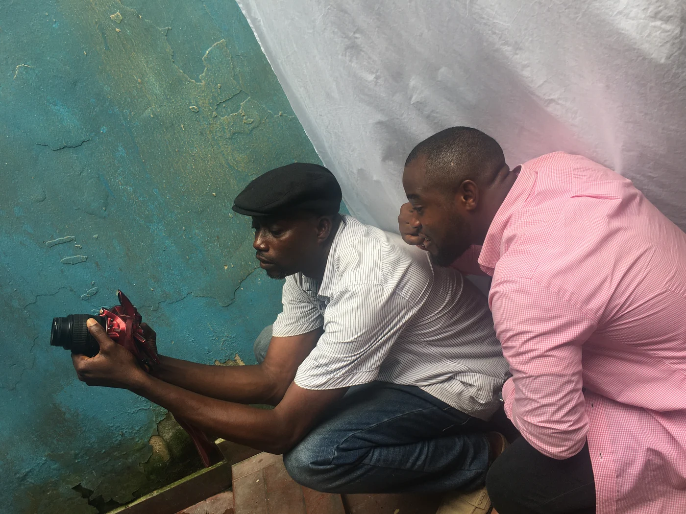 Two people learning about a camera in a practical SkillUp Africa session