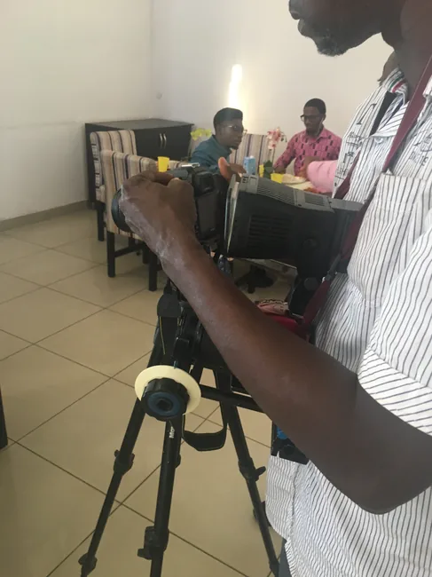A participant operating a video camera on a tripod during a SkillUp Africa workshop