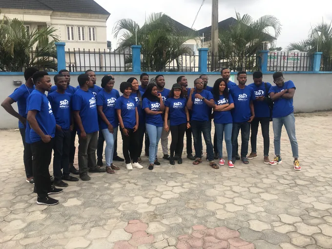 People wearing blue SkillUp Africa shirts standing together outdoors