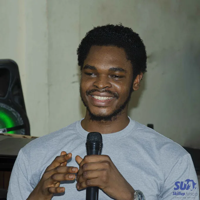 A smiling SkillUp Africa participant holding a microphone