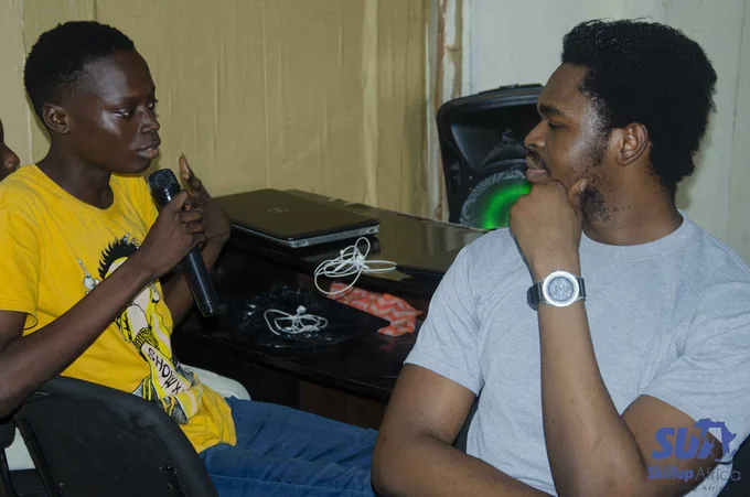 Two participants sharing a conversation, one holding a microphone