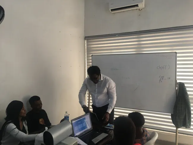 A SkillUp Africa facilitator working with a small group around laptops